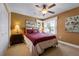 Bedroom features a large window, ceiling fan, closet, bedside tables, and artwork at 1612 Fairway Oaks Dr, Palmetto, FL 34221