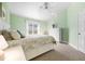 Inviting bedroom featuring a bright window, a ceiling fan, and a full bed with decorative pillows at 1612 Fairway Oaks Dr, Palmetto, FL 34221