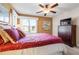 Bedroom featuring a ceiling fan, a window with neighborhood views, a dresser, and a decorative bed at 1612 Fairway Oaks Dr, Palmetto, FL 34221