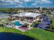 Aerial view of a community clubhouse with a pool, lounge area, and tropical landscaping, perfect for relaxation at 1612 Fairway Oaks Dr, Palmetto, FL 34221