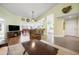 Open-concept living room featuring wood floors, a ceiling fan, and views into dining and kitchen areas at 1612 Fairway Oaks Dr, Palmetto, FL 34221