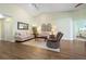 Bright living room with vaulted ceilings, wood floors, neutral furniture, and a view into the bedroom at 1612 Fairway Oaks Dr, Palmetto, FL 34221