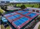 Aerial view of well-maintained pickleball and tennis courts surrounded by lush greenery at 1612 Fairway Oaks Dr, Palmetto, FL 34221