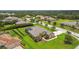 A well-manicured lawn and tropical landscaping surround this home with a screened pool at 16246 26Th E St, Parrish, FL 34219