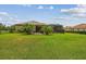 Expansive backyard with lush green lawn, mature landscaping, and screened lanai at 16246 26Th E St, Parrish, FL 34219