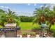 Grilling area with a beautiful view of the yard and lush tropical landscaping at 16246 26Th E St, Parrish, FL 34219