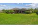 An open backyard with a covered patio and lush green grass at 16246 26Th E St, Parrish, FL 34219