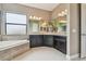 Bathroom with a soaking tub, tile surround, a spacious double sink vanity, and contemporary lighting fixtures at 16246 26Th E St, Parrish, FL 34219