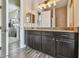 Bathroom featuring dark wood cabinets, granite countertop, tile flooring, and walk-in shower at 16246 26Th E St, Parrish, FL 34219