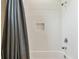 Close-up of the bathtub and shower with tiled surround, accented by a shower curtain at 16246 26Th E St, Parrish, FL 34219