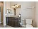 Bathroom with dark wood cabinets, granite countertop, toilet and wood-look tile flooring at 16246 26Th E St, Parrish, FL 34219