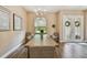 Dining room featuring a long wooden table, chandelier, wood-look tile, and adorned double-door entry at 16246 26Th E St, Parrish, FL 34219