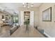 Open dining area leading to the living room, showcasing wood-look tile, chandelier, and stylish decor at 16246 26Th E St, Parrish, FL 34219
