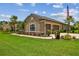 Single-story home featuring a two-car garage, manicured lawn, and beautiful landscaping at 16246 26Th E St, Parrish, FL 34219