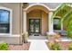 A welcoming entry featuring a decorative front door flanked by columns and mature landscaping at 16246 26Th E St, Parrish, FL 34219