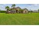 Well-maintained front yard of a single-story home with lush green grass and palm trees at 16246 26Th E St, Parrish, FL 34219