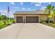 Two-car garage with an extended driveway and well-manicured landscaping in front at 16246 26Th E St, Parrish, FL 34219