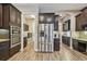 Kitchen with stainless steel appliances, dark cabinets, and wood-look tile flooring at 16246 26Th E St, Parrish, FL 34219