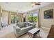Living room featuring access to a screened-in patio, ceiling fans, and neutral-colored walls at 16246 26Th E St, Parrish, FL 34219