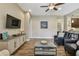 Living room showcasing mounted TV, sleek console, and a view into the kitchen at 16246 26Th E St, Parrish, FL 34219