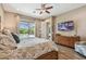Bedroom with ceiling fan, en-suite bath and sliding doors providing serene views of the screened pool and garden at 16246 26Th E St, Parrish, FL 34219
