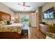 Bright main bedroom boasts wood floors, ceiling fan, and sliding doors to the pool area for private access at 16246 26Th E St, Parrish, FL 34219