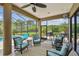 Relaxing screened patio with ceiling fan, comfortable seating, and a view of the pool and lush backyard at 16246 26Th E St, Parrish, FL 34219
