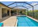 Beautiful pool area with a screened enclosure, spa, outdoor kitchen, and ample seating at 16246 26Th E St, Parrish, FL 34219
