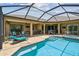 Screened-in pool and patio area with lounge chairs and an outdoor bar at 16246 26Th E St, Parrish, FL 34219