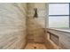 Tiled shower featuring a built-in niche, overhead fixture, and a glass block window providing additional light at 16246 26Th E St, Parrish, FL 34219