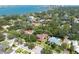 Aerial view of the home and neighborhood with an overlay circle featuring lush green trees and stunning water views at 1671 South Dr, Sarasota, FL 34239