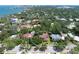 Aerial view of the home and neighborhood with an overlay circle featuring lush green trees and stunning water views at 1671 South Dr, Sarasota, FL 34239