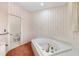 Bathroom featuring a soaking tub and decorative wallpaper at 1671 South Dr, Sarasota, FL 34239