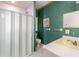 Bathroom features a shower with glass doors, a vanity, and vibrant green wallpaper at 1671 South Dr, Sarasota, FL 34239