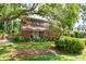 View of the rear exterior elevation of a two-story brick home with mature trees at 1671 South Dr, Sarasota, FL 34239