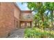 Exterior view of brick facade with covered patio, balcony, and lush landscaping at 1671 South Dr, Sarasota, FL 34239