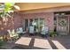 A spacious covered front porch with chairs, planters, brick flooring, and a wooden front door at 1671 South Dr, Sarasota, FL 34239