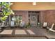 Covered front porch with chairs, planters, brick flooring and a beautiful wooden front door at 1671 South Dr, Sarasota, FL 34239