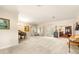 Large, neutral living room with a piano, white carpet, and french doors that lead to the exterior at 1671 South Dr, Sarasota, FL 34239
