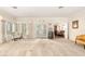 Large, neutral living room with a piano, white carpet, and french doors that lead to the exterior at 1671 South Dr, Sarasota, FL 34239