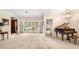 Bright living room with a piano, chandelier, and large windows overlooking the outside at 1671 South Dr, Sarasota, FL 34239