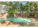In-ground pool surrounded by a decorative stucco wall and tropical foliage creates a private oasis at 1671 South Dr, Sarasota, FL 34239