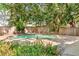 In-ground pool surrounded by a decorative stucco wall and tropical foliage creates a private oasis at 1671 South Dr, Sarasota, FL 34239