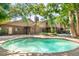 Backyard pool with brick exterior and mature trees creates a relaxing backyard retreat at 1671 South Dr, Sarasota, FL 34239