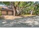 Street view of a charming home featuring mature shade trees, a brick exterior, and a two car garage at 1671 South Dr, Sarasota, FL 34239