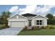 Inviting single-story home with a two-car garage, stone accents, well-manicured lawn, and lush landscaping at 1758 Cobb Trl, Parrish, FL 34219