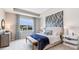 Well-lit bedroom with stylish wallpaper, tray ceiling, and coordinated blue and white accents at 18106 Cropside Trl, Lakewood Ranch, FL 34211
