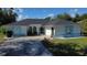 Charming single-story home with blue trim, landscaped front yard, and inviting curved driveway at 21498 Beaverton Ave, Port Charlotte, FL 33952