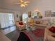 Inviting living room features tile floors, a ceiling fan, and sliding glass door to the pool at 21498 Beaverton Ave, Port Charlotte, FL 33952