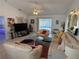 Spacious living room with comfortable seating, a ceiling fan, and sliding glass doors to the pool at 21498 Beaverton Ave, Port Charlotte, FL 33952